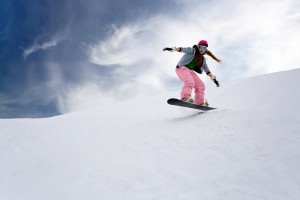 Snowboarder i pink skibukser på vej ned ad bakke
